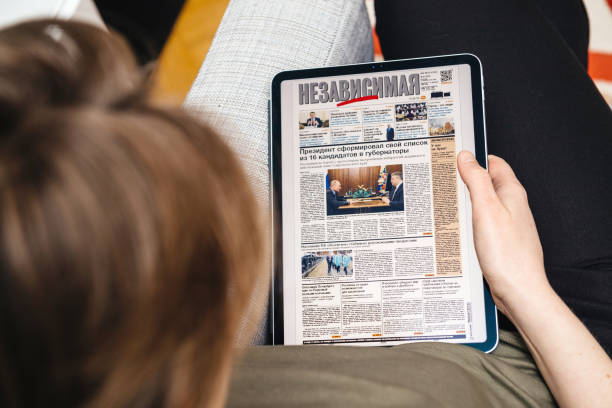 woman reading on ipad pro nezavisimaya gazeta about russia - editorial use flash imagens e fotografias de stock