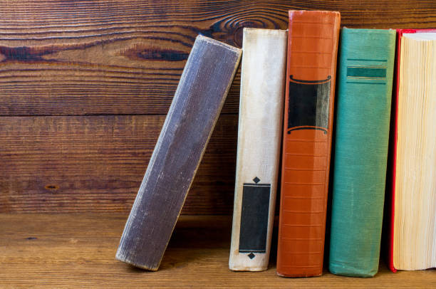 本棚に古い本が積み上げられている - book book spine shelf in a row ストックフォトと画像