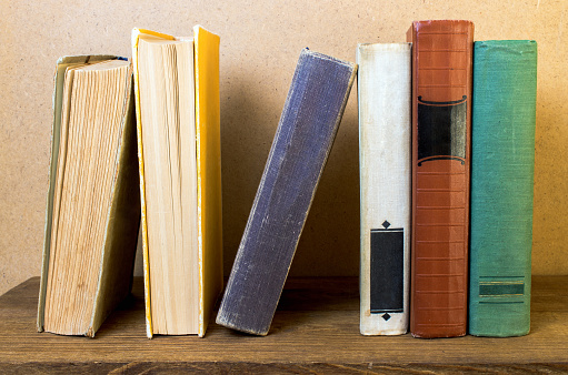 old books stacked on a bookshelf