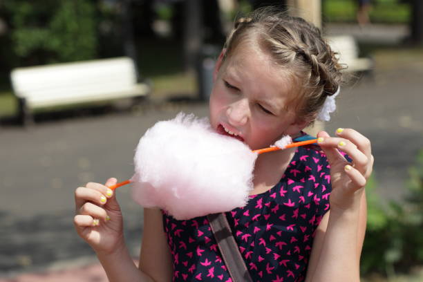 istock Girl licks cotton candy 1154421605