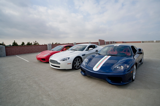 Cerritos, CA, USA - March 14, 2009:  A red Ferrari 360 Modena, Aston Martin V8 Vantage, and Ferrari 360 Challenge Stradale sports cars in Cerritos, CA on March 14, 2009. All three cars are powered by V8 engines.