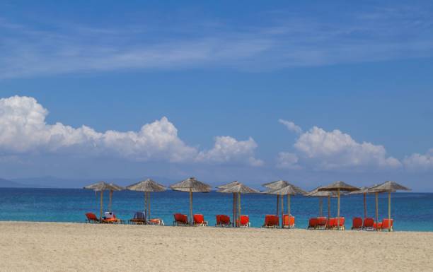 istock Sunbeds and straw umbrellas on a sandy beach. 1154430395