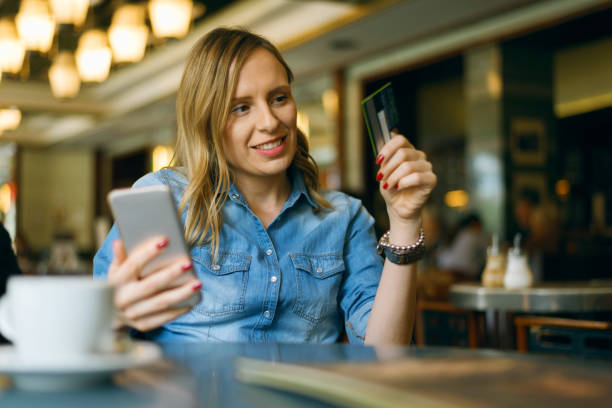 istock Woman making credit card purchase online using mobile phone 1154435545