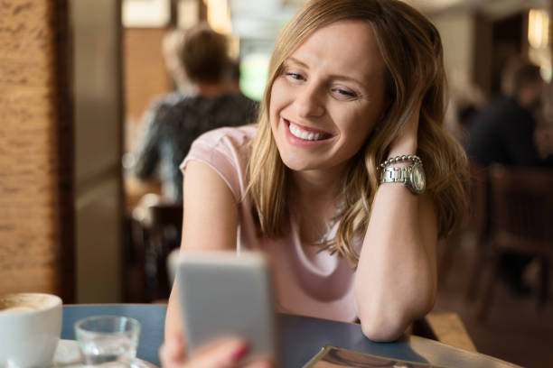 istock Young woman text messaging on mobile phone in a cafe 1154435751