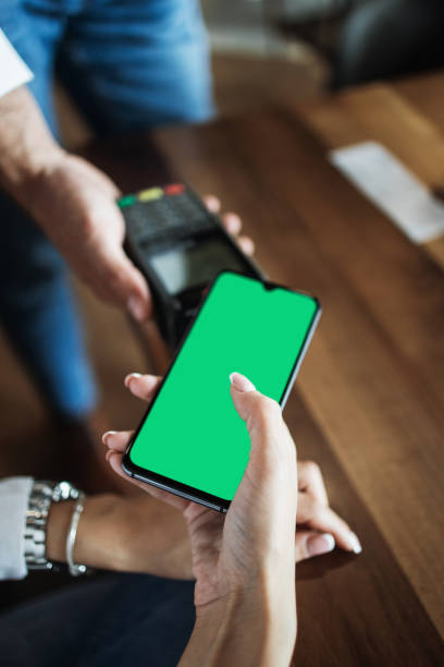 Close up hand making NFC payment using smart phone Customer making payment in modern cafe or restaurant by smartphone using NFC (near field communication) wireless technology. Close up shot. Consumer technology concept. quick service restaurant cashier stock pictures, royalty-free photos & images