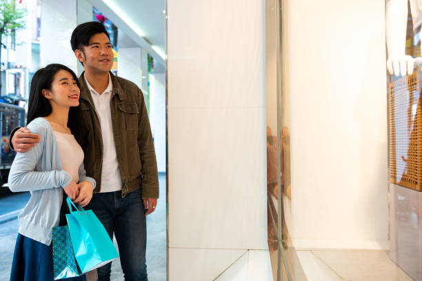 istock Smiling couple looking at store window in city 1154436864