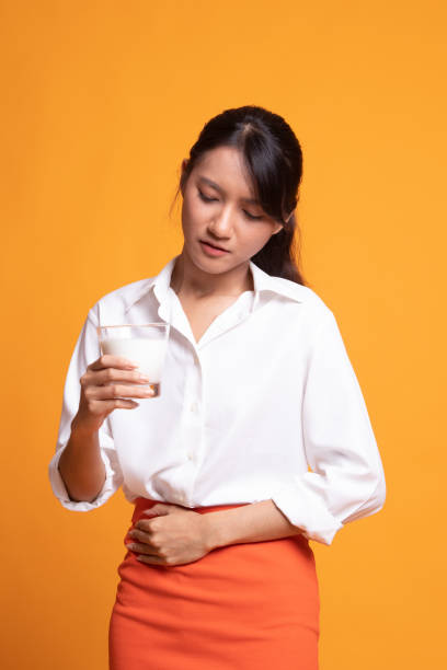 femme asiatique buvant un verre de lait a eu la douleur stomachache. - got milk photos et images de collection