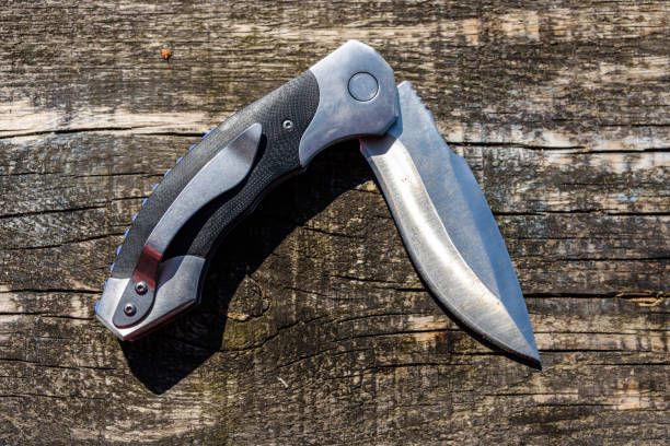 istock Folding knife on the rustic wooden background 1154440491