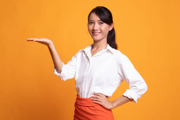 istock Young Asian woman present with her hand. 1154441670