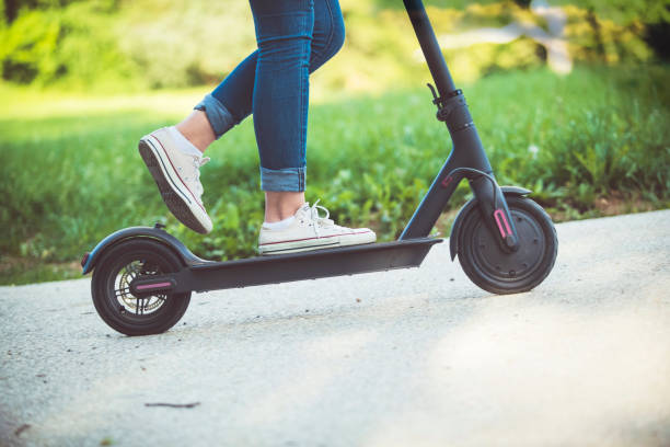 istock Woman riding motor scooter at park 1154441734