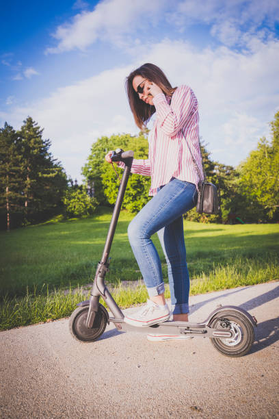 istock Woman riding motor scooter at park 1154441740