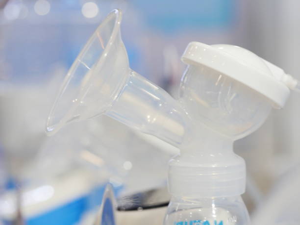 istock Automatic breast pump with mothers breasts milk 1154443096