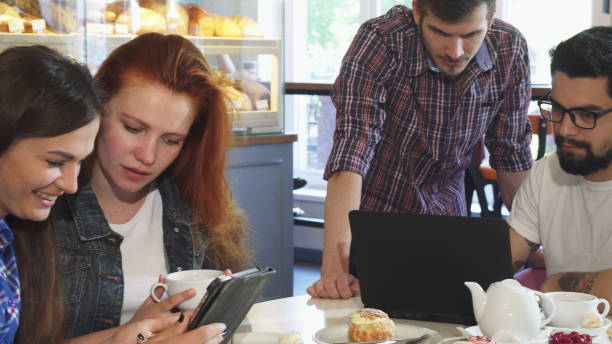 istock Group of young friends having breakfast together using gadgets 1154444942