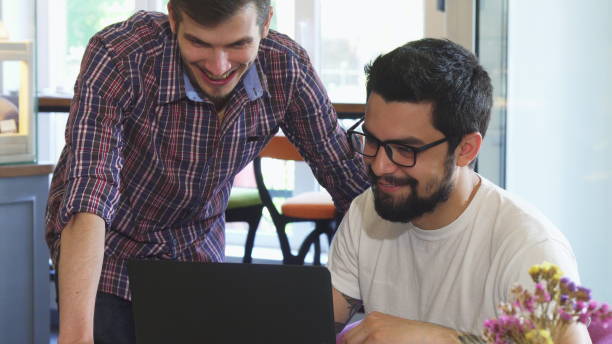 istock Two young men using laptop together at the coffee shop 1154444958