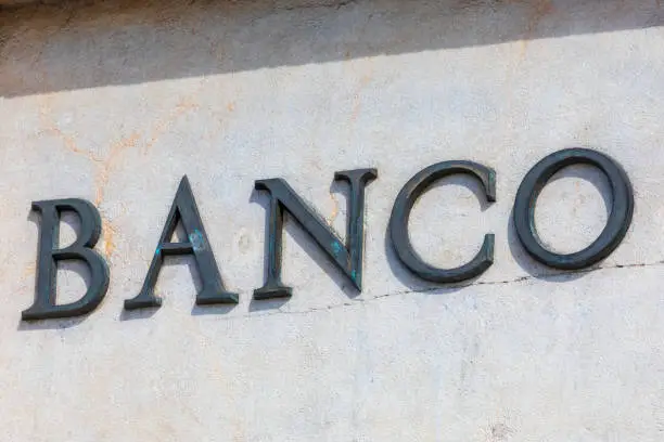 Photo of Bank word in Spanish. Metallic lettering.