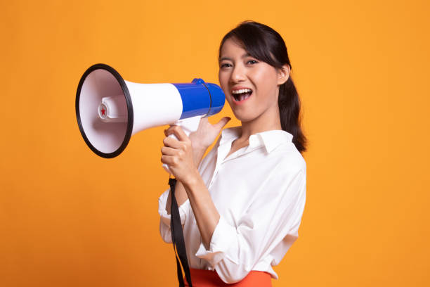 istock Beautiful young Asian woman announce with megaphone. 1154445607