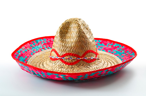 Cinco de mayo, traditional mexican hat and caribbean culture concept theme with close up on wicker or straw sombrero decorated in bright colors isolated on white background with a clipping path cut out