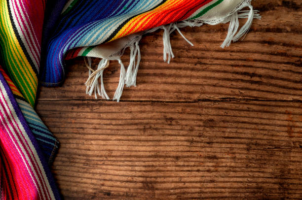 el tema conceptual del cinco de mayo fiesta y las culturas indígenas de méxico con una alfombra mexicana llamada sarape aislado sobre fondo de madera con copyspace - mexicanos fotografías e imágenes de stock