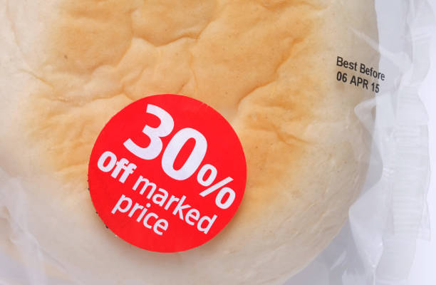 Discount sticker attached to cellophane bread packaging. 30 per cent off marked price. Best before date printed on packaging