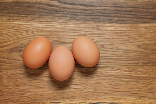 istock Three brown hens eggs shot from above on a wooden table 1154447640