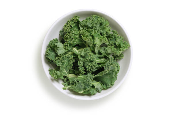 Chopped kale in a white bowl, shot from above isolated on white with clipping path