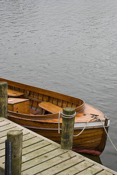 istock Wooden rowing boat tied up alongside pier 115444861
