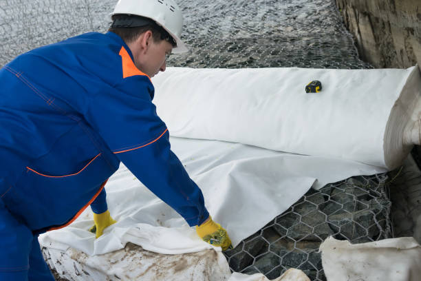 istock a worker in overalls covers stones and iron mesh with a cloth 1154448920