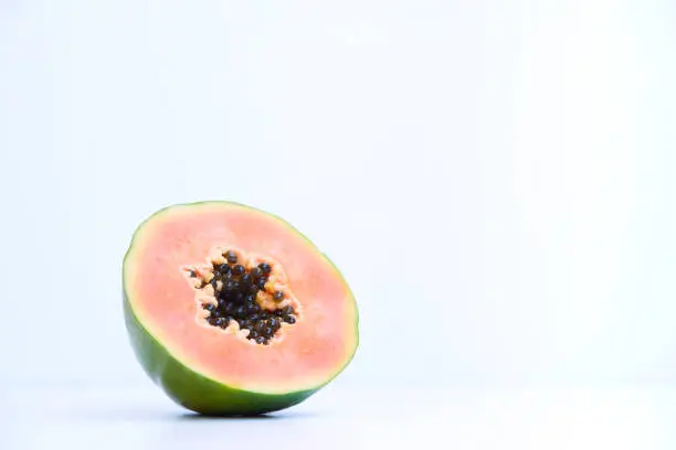 Slice of papaya on white background with copy space