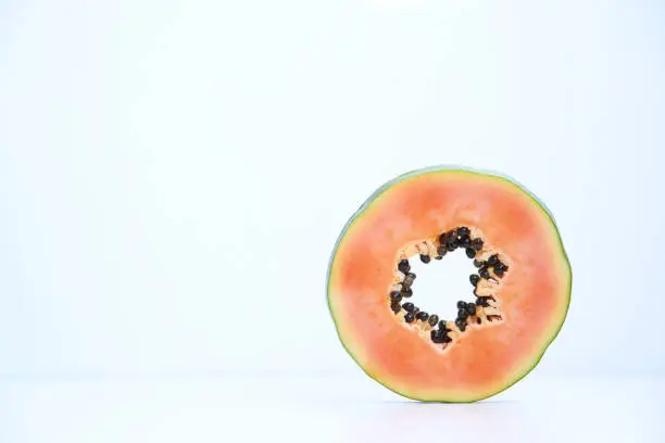 Slice of papaya on white background, copy space