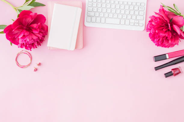 istock Flat lay blogger or freelancer workspace with a notebook, keyboard, red peonies on a pink background 1154450657