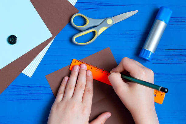 istock Child makes greeting card for Father's Day. Step 2 1154451712