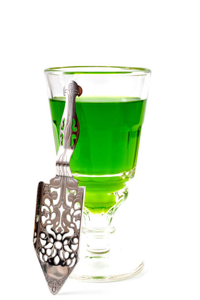 Alcoholic drink, creative stimulant and bohemian lifestyle concept theme with glass of green absinthe and stainless steel spoon isolated on white background Alcoholic drink, creative stimulant and bohemian lifestyle concept theme with glass of green absinthe and stainless steel spoon isolated on white background absinthe spoon stock pictures, royalty-free photos & images