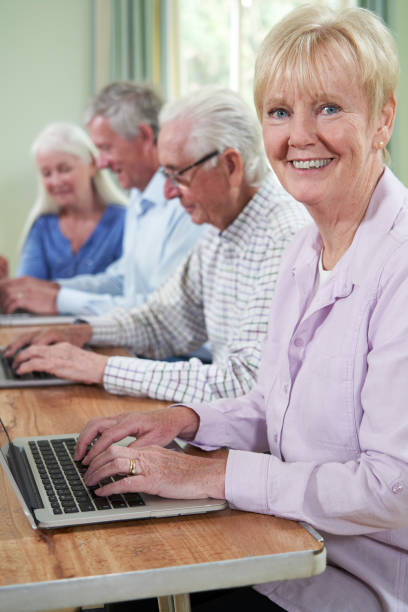 istock Portrait Of Senior Woman With Tutor In Computer Class 1154454683