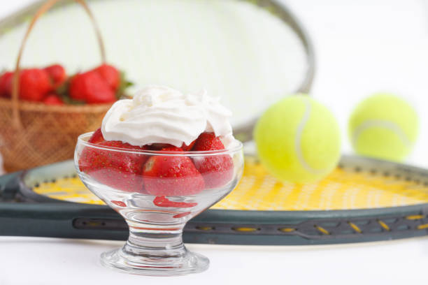 Strawberries with whipped cream and  tennis equipment on Wimbledon tournament stock photo