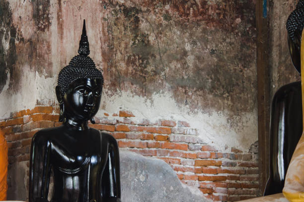 istock Black buddha statue with old walls 1154458649