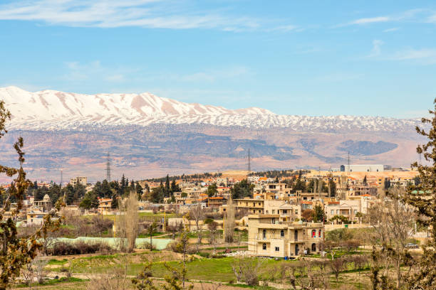 lebanese houses in beqaa valley with snow cap mountains in the background, baalbeck, lebanon - baalbek imagens e fotografias de stock