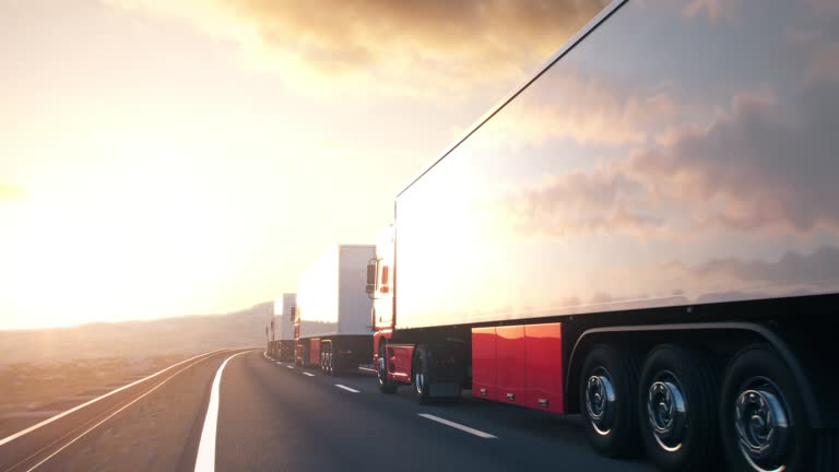 convoy of semi-trailer trucks driving into the sunset