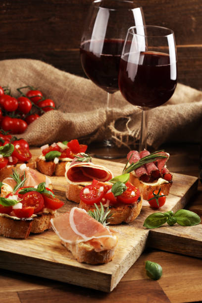 istock antipasto various appetizer. Cutting board with prosciutto, salami, cheese, bread and olives on dark wooden background 1154460026