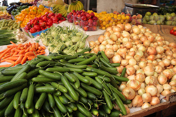Tripoli, Lebanon - September 8, 2010: Lebanese shop in the souk in the old city of Tripoli, here passing near stacks of vegetables and fruit. People have lived in Tripoli for at least 3000 years