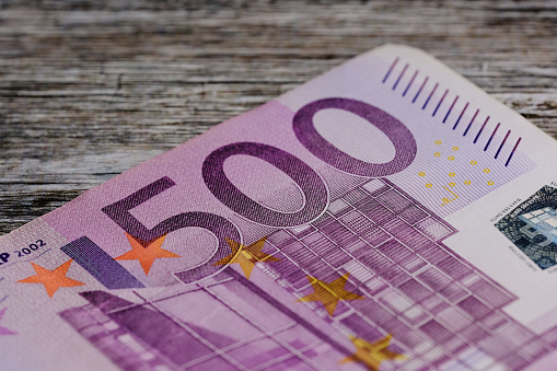 macro photo of five hundred Euro banknote against wooden brown background