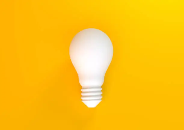 Photo of Light bulb on pastel yellow background