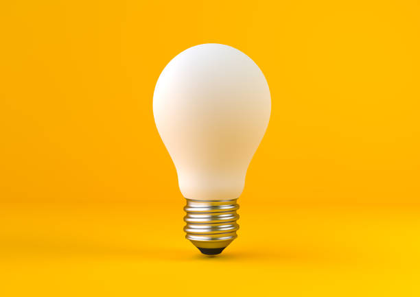 żarówka na pastelowym żółtym tle - light bulb compact fluorescent lightbulb lamp fluorescent light zdjęcia i obrazy z banku zdjęć