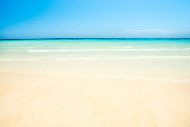 White sand beach and clear sea water under blue sky. Can be used as summer vacation background