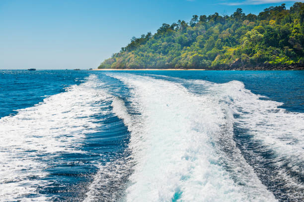istock Wake of boat on water surface beside island coast 1154468655
