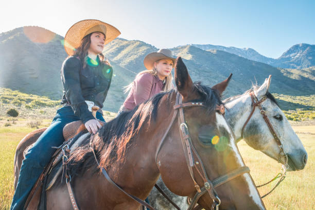 Adult Horsewomen Pausing on a Ride Through Utah Ranch Land Female ranchers pausing on horseback to survey the Utah grassland on a sunny day. 2667 stock pictures, royalty-free photos & images