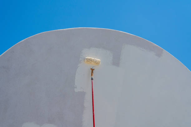 istock Worker repainting traditional cave house on Santorini 1154469652