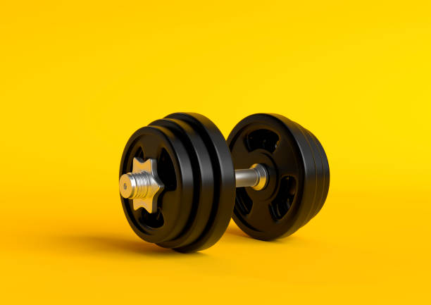 istock Dumbbell with black plates isolated on pastel yellow background 1154470787