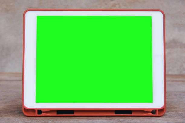 istock Mockup image of  White tablet pc with blank green desktop screen on wooden table 1154473449