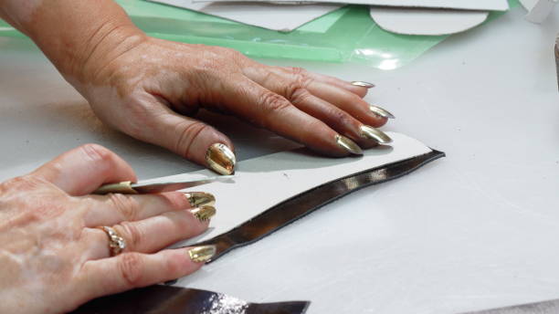 istock Female shoemaker cutting leather pieces at her workshop 1154474558