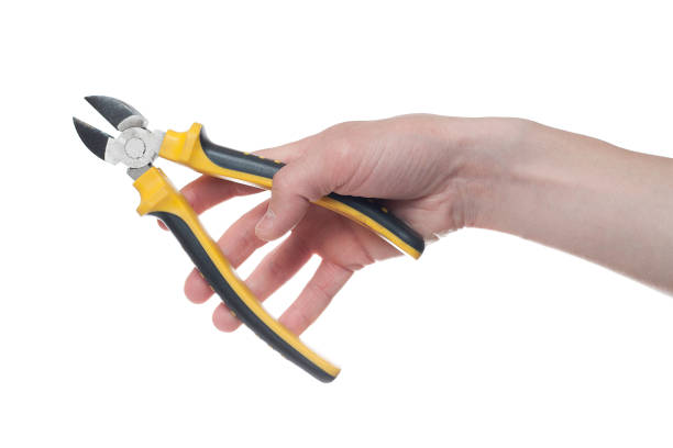 istock Man's hand holding a black and yellow wire cutter. Open, clean, ready to cut form. 1154474717